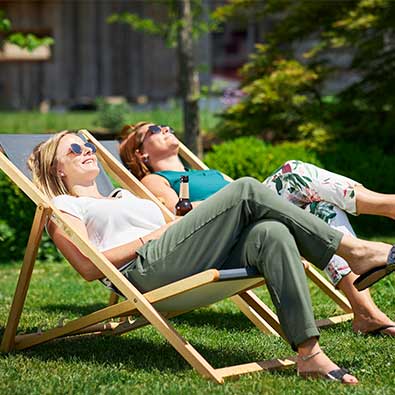 Frauen genießen die Sonne in Liegestühlen