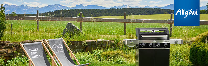 Videro gas barbecue next to Rösle deckchairs against a mountain backdrop 