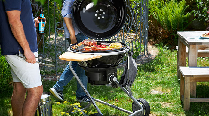 Barbecue with barbecue tongs on charcoal barbecue F60