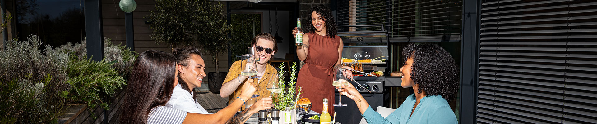 RÖSLE Blog Freunde stoßen zusammen auf einen tollen Grillabend an.