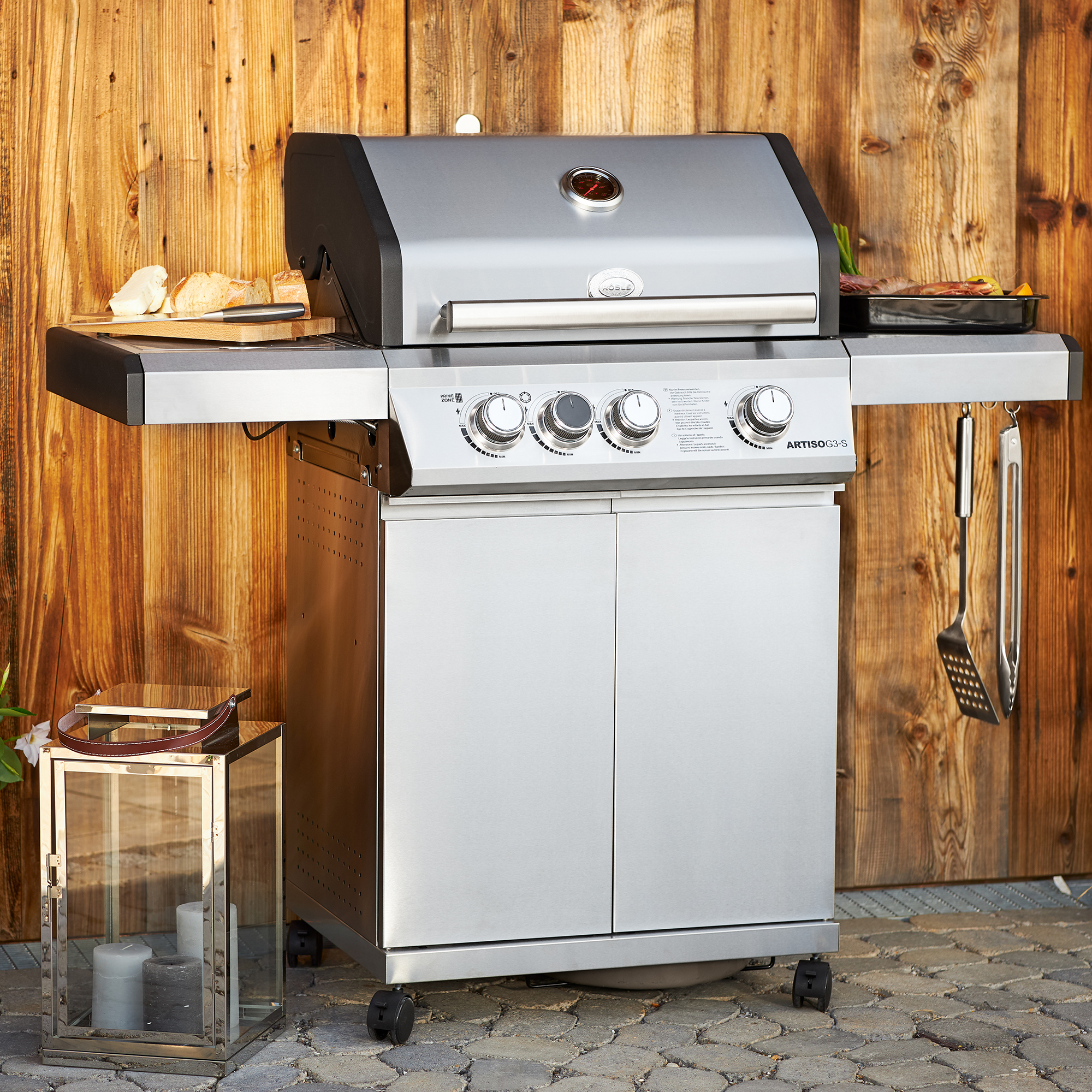 Gasgrill BBQ Station Artiso G3-S aus Edelstahl mit drei Reglern und seitlichen Ablageflächen.