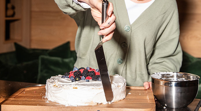 Küchenhelfer Frau streicht Torte mit dem Tortenspachtel von RÖSLE glatt