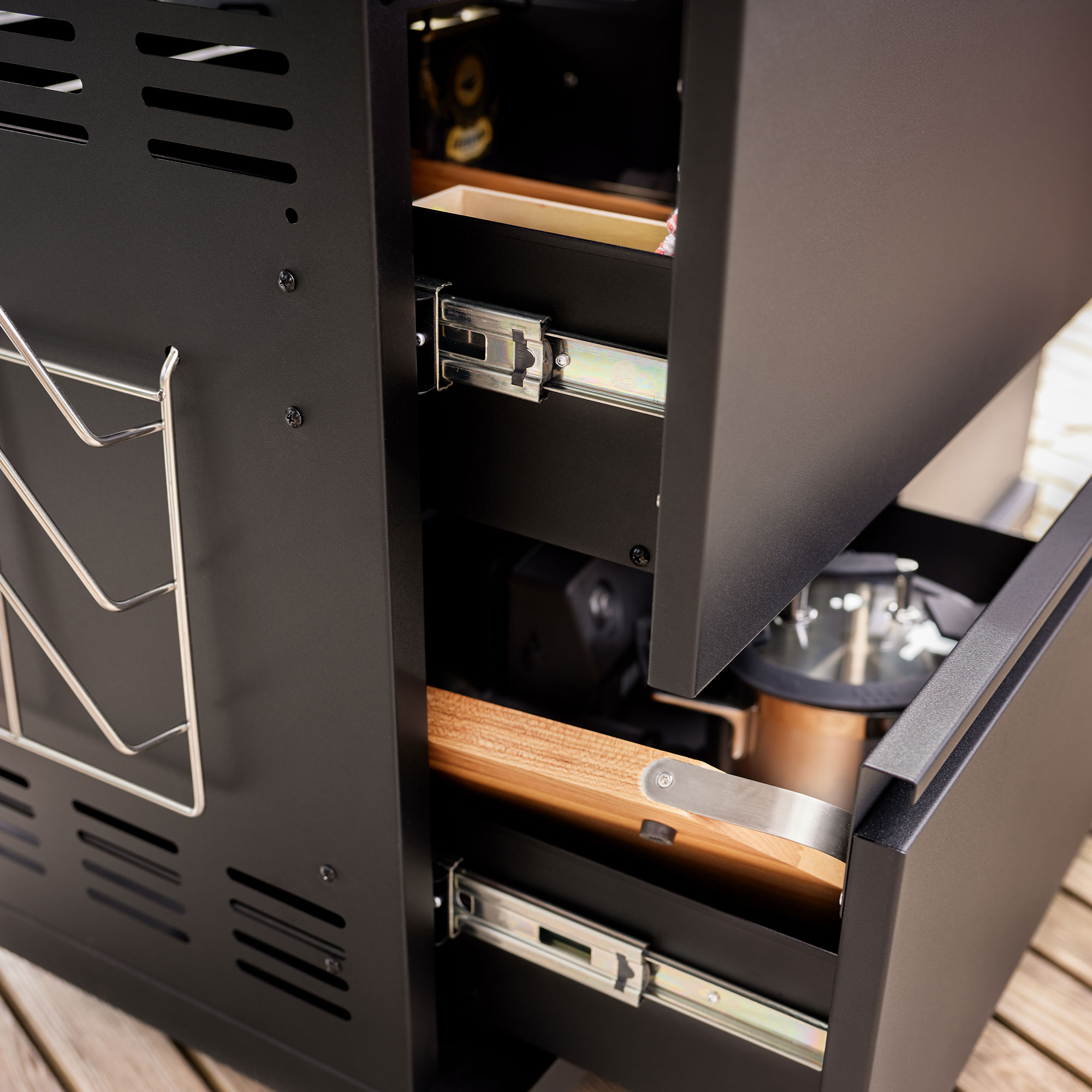 Gasgrill Videro G6-S PRO mit Schubladen Gasgrill Videro G6-S PRO mit offenen Schubladen, die Holz- und Grillzubehör zeigen.