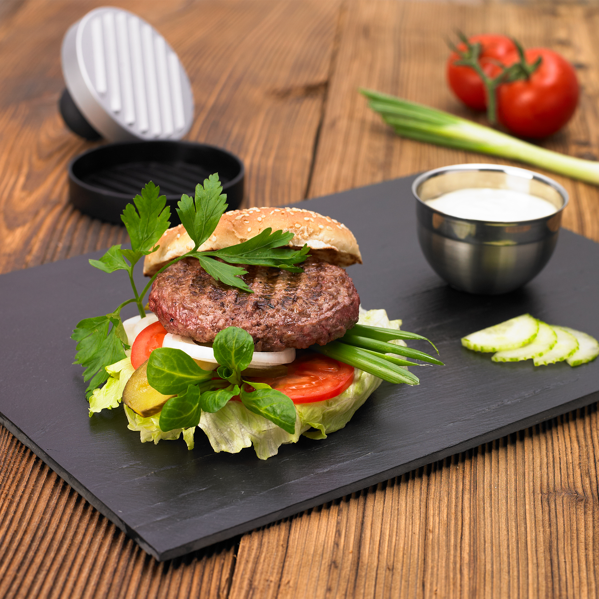 Frisch zubereiteter Burger mit RÖSLE Burgerpresse Burgerpresse mit einem frisch zubereiteten Burger, belegt mit Salat, Tomaten, Zwiebeln und...