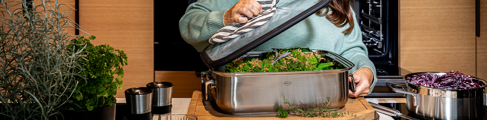 Bräter SILENCE PRO Frau öffnet Deckel des Bräters in der Küche