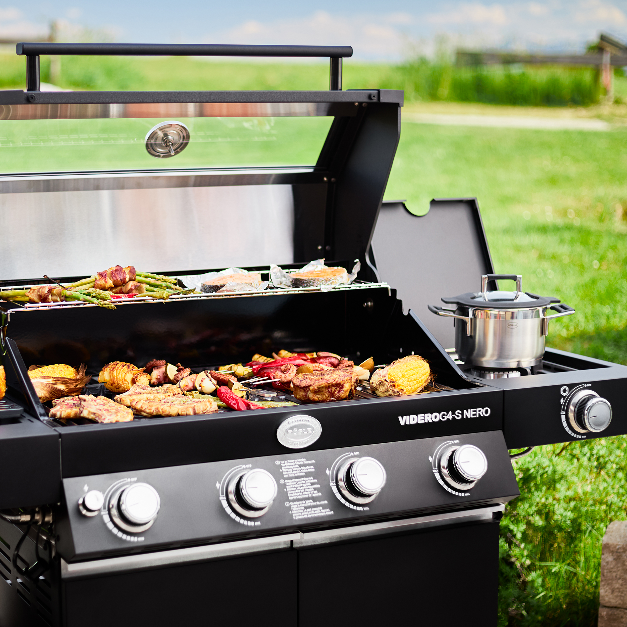 RÖSLE Gasgrill Videro G4-S Nero Gasgrill Videro G4-S Nero mit geöffnetem Deckel, Grillfläche mit verschiedenen Grillgerichten...
