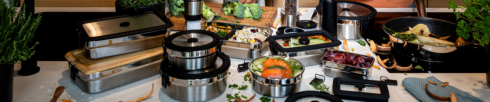 Runde und eckige Dosen mit Deckel auf dem Küchentresen mit vielen Lebesnmitteln