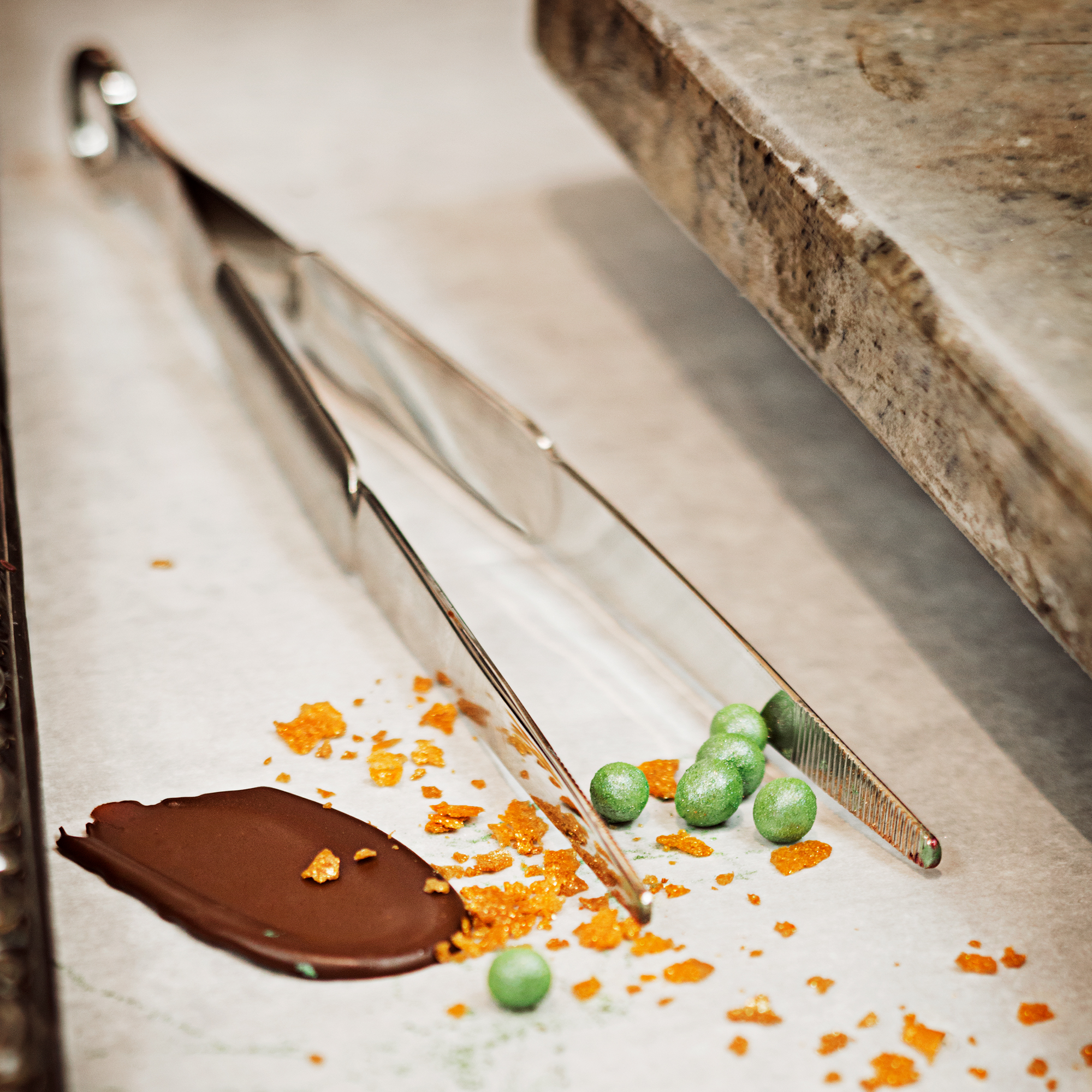 RÖSLE patisserie tongs on work surface Stainless steel patisserie tongs, on a work surface with chocolate and decoration.