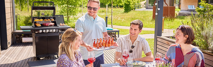 Friends sit at the table and are served chicken on a chicken rack