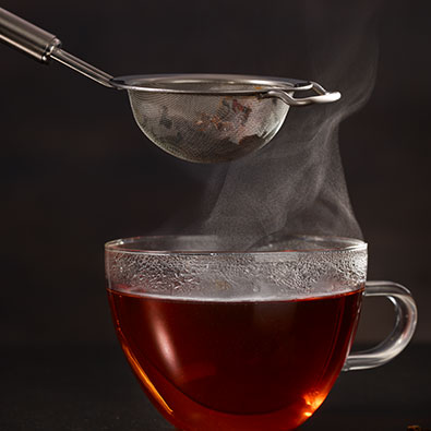 Heiße Tasse Tee mit Teesieb