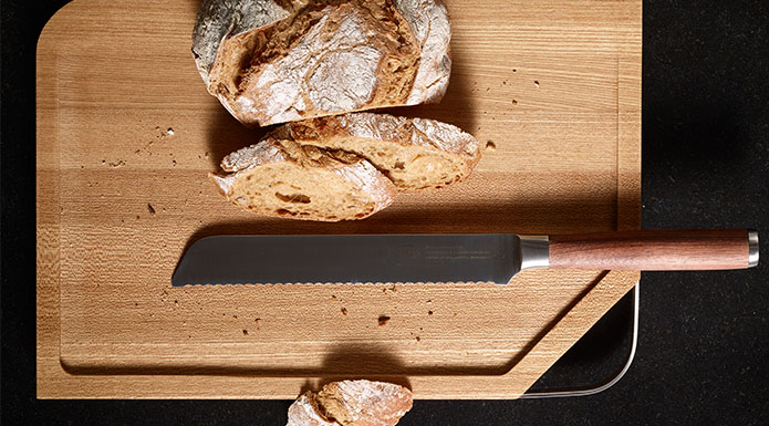 Cutting board with stainless steel handle Cutting bread with bread knife Masterclass on the cutting board with stainless steel handle