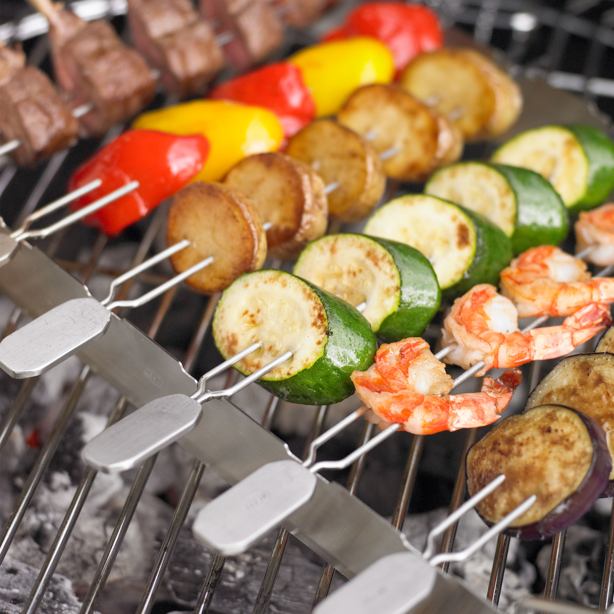 Barbecue skewers from RÖSLE Grill skewers with vegetables, prawns and meat on a grill rack.