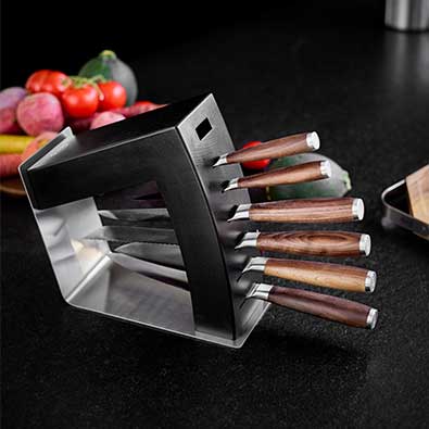 Black knife block equipped with knives lying on its side.