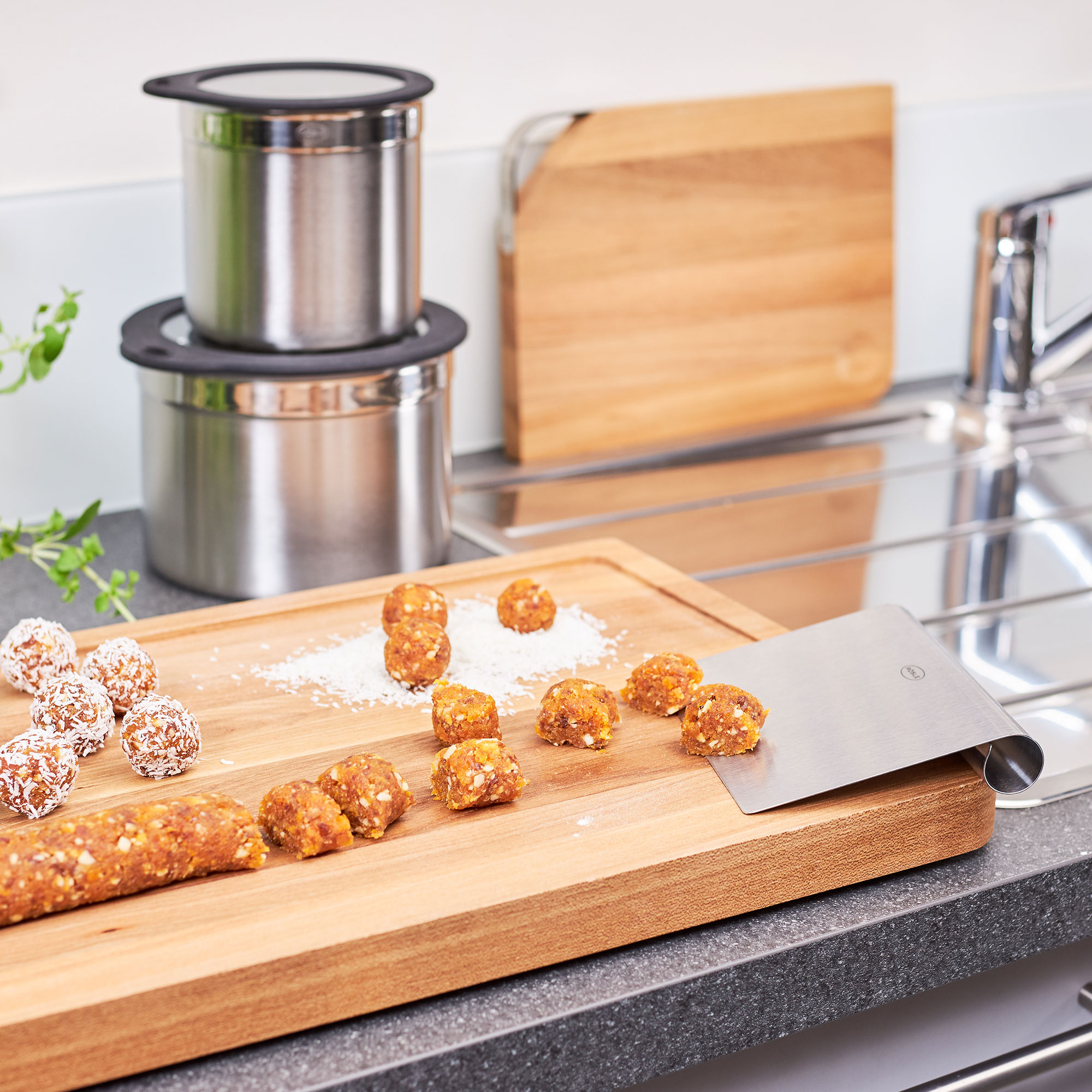 RÖSLE baking spatula on wooden board with dough balls Stainless steel baking spatula on a wooden board, surrounded by small balls of dough and a...