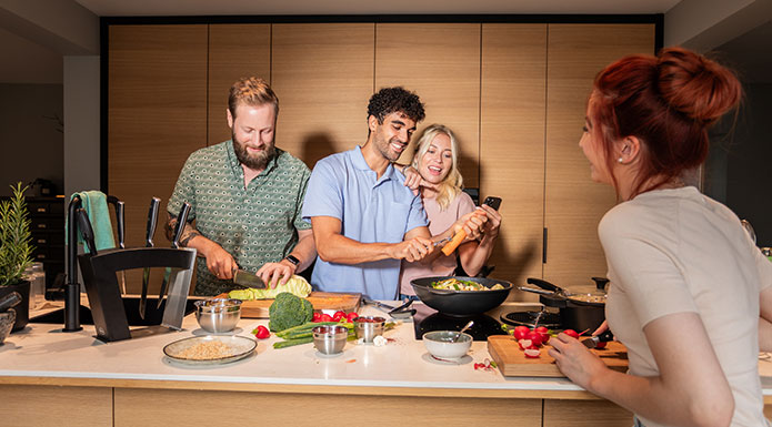 Kochgeschirr Serie CADINI Freunde kochen zusammen mit den Pfannen und dem Wok der Kochgeschirr Serie CADINI