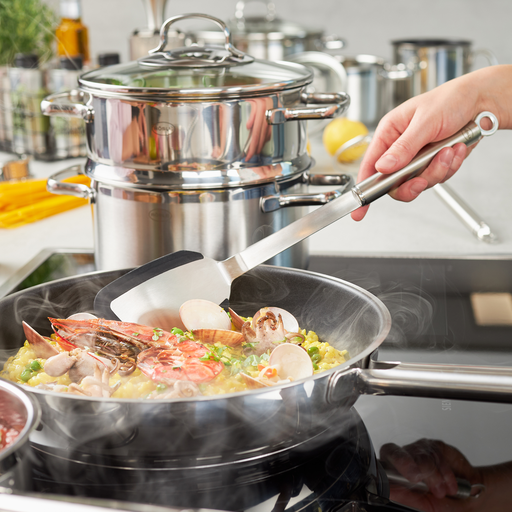 RÖSLE Silikon Pfannenwender in Aktion Pfannenwender mit Rundgriff aus Silikon, beim Wenden von Meeresfrüchten in einer Pfanne.