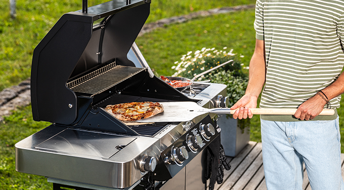 Pizzaschieber Fertige Pizza auf dem Pizzaschieber