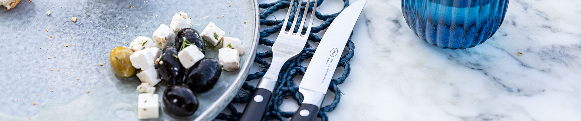 Ersatzteilsuche Steakbesteck von RÖSLE auf dem Tisch neben einem Teller.