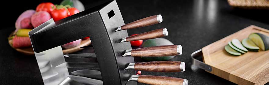 RÖSLE messenblok met messen Messenblok met vijf messen, houten handvatten, roestvrij staal, op een zwarte tafel met groenten...