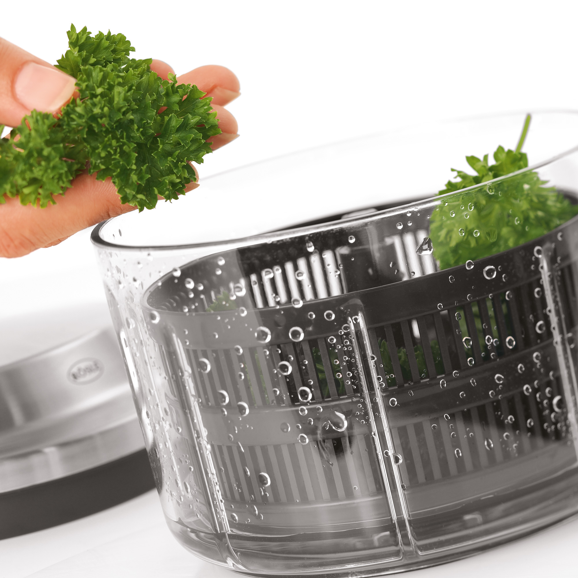 RÖSLE Multischneider mit frischen Kräutern Multischneider mit frischer Petersilie, die in den Behälter gegeben wird.