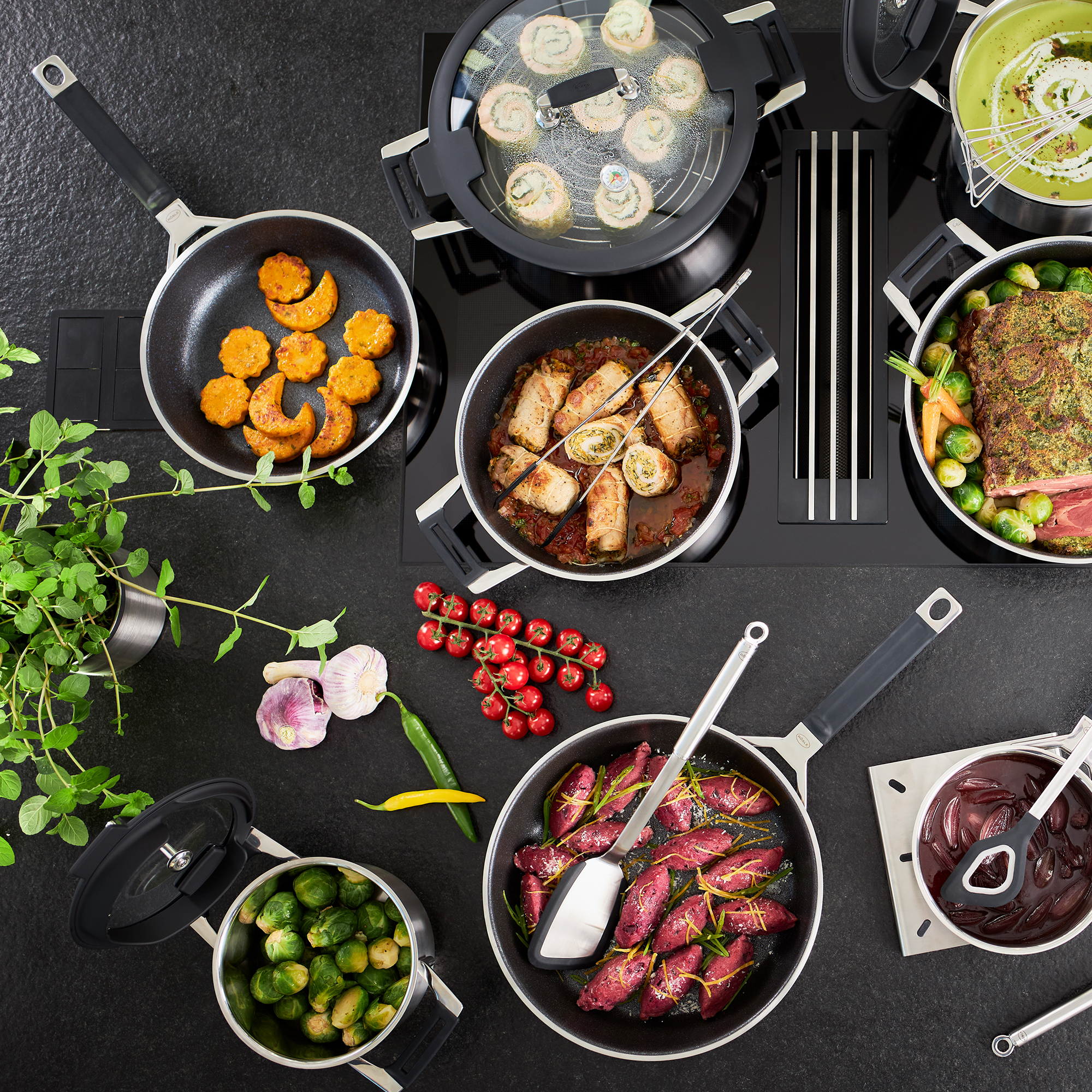 RÖSLE frying pan with various dishes Frying pan with various dishes such as vegetables, meat and side dishes on a hob.