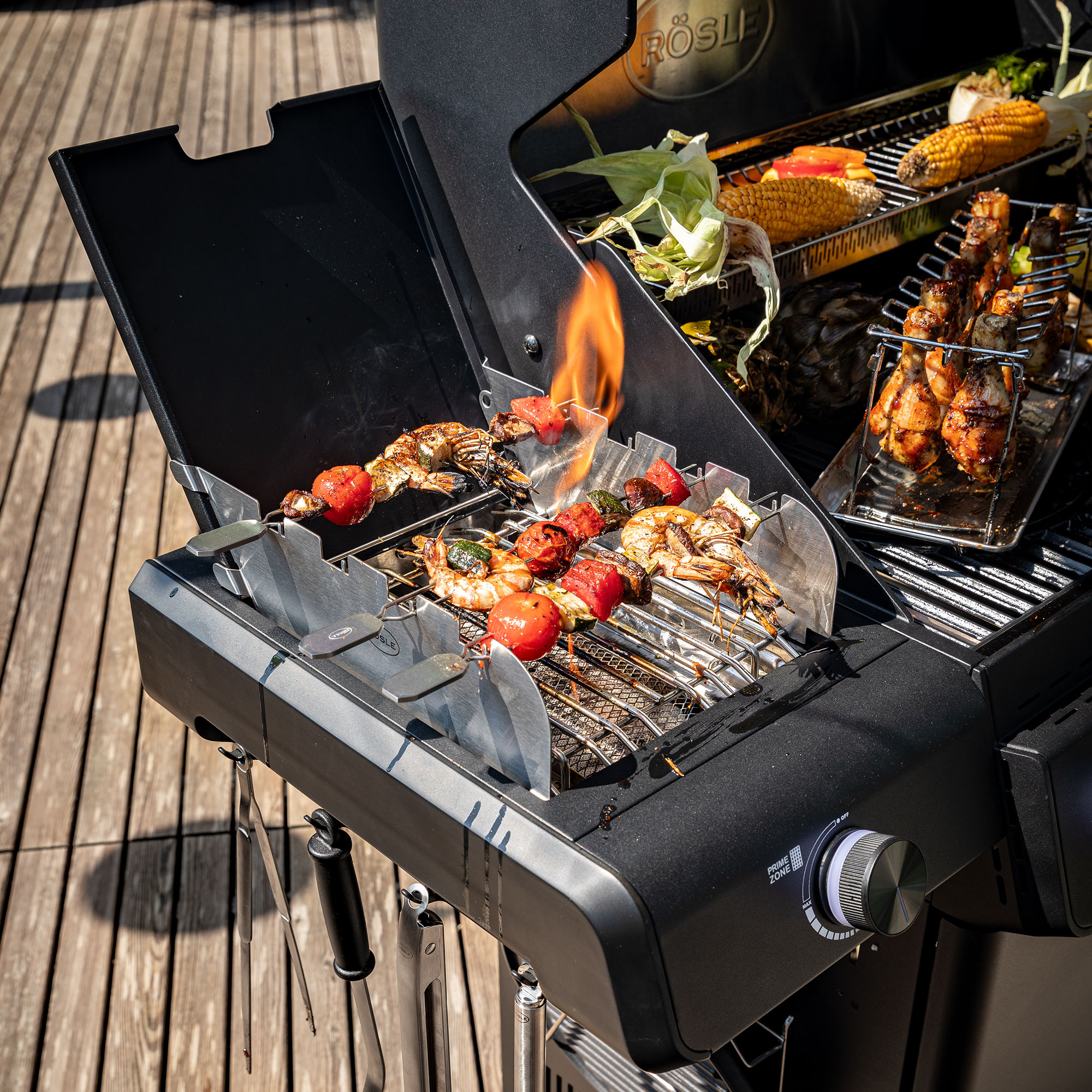 RÖSLE Allflame Grill mit Grillgut Allflame Grill mit Gemüse und Fleischspießen, Flammenbildung sichtbar, Grillrost aus Edelstahl.