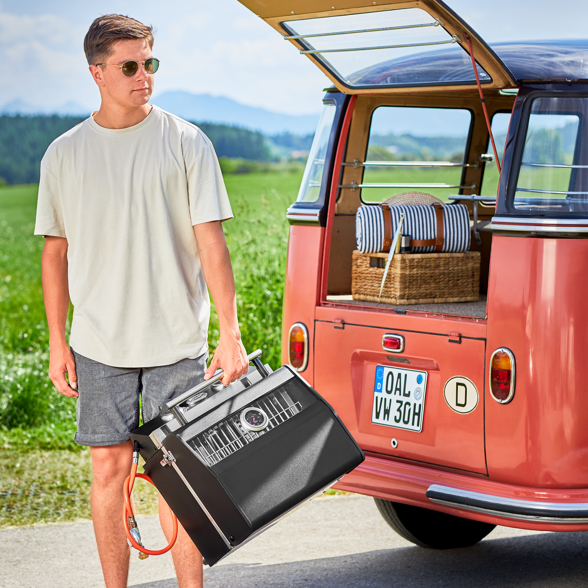 Tragbarer Gasgrill Videro G2-P von RÖSLE Gasgrill Videro G2-P in tragbarem Design, schwarz, wird von einem Mann in lässiger Kleidung...