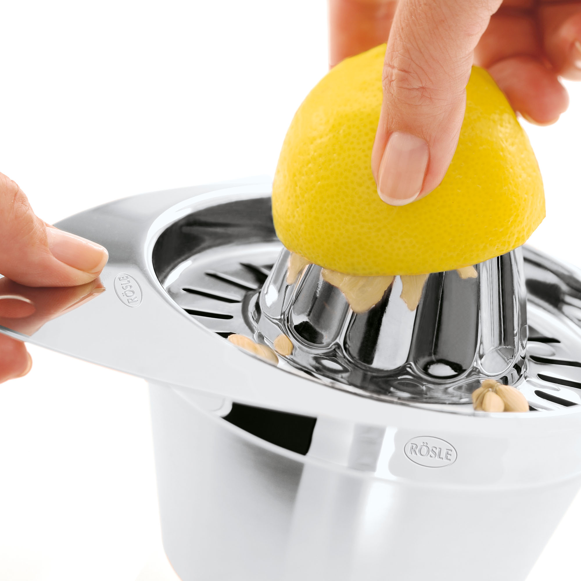 RÖSLE stainless steel lemon squeezer Stainless steel lemon squeezer with half a lemon held for squeezing.