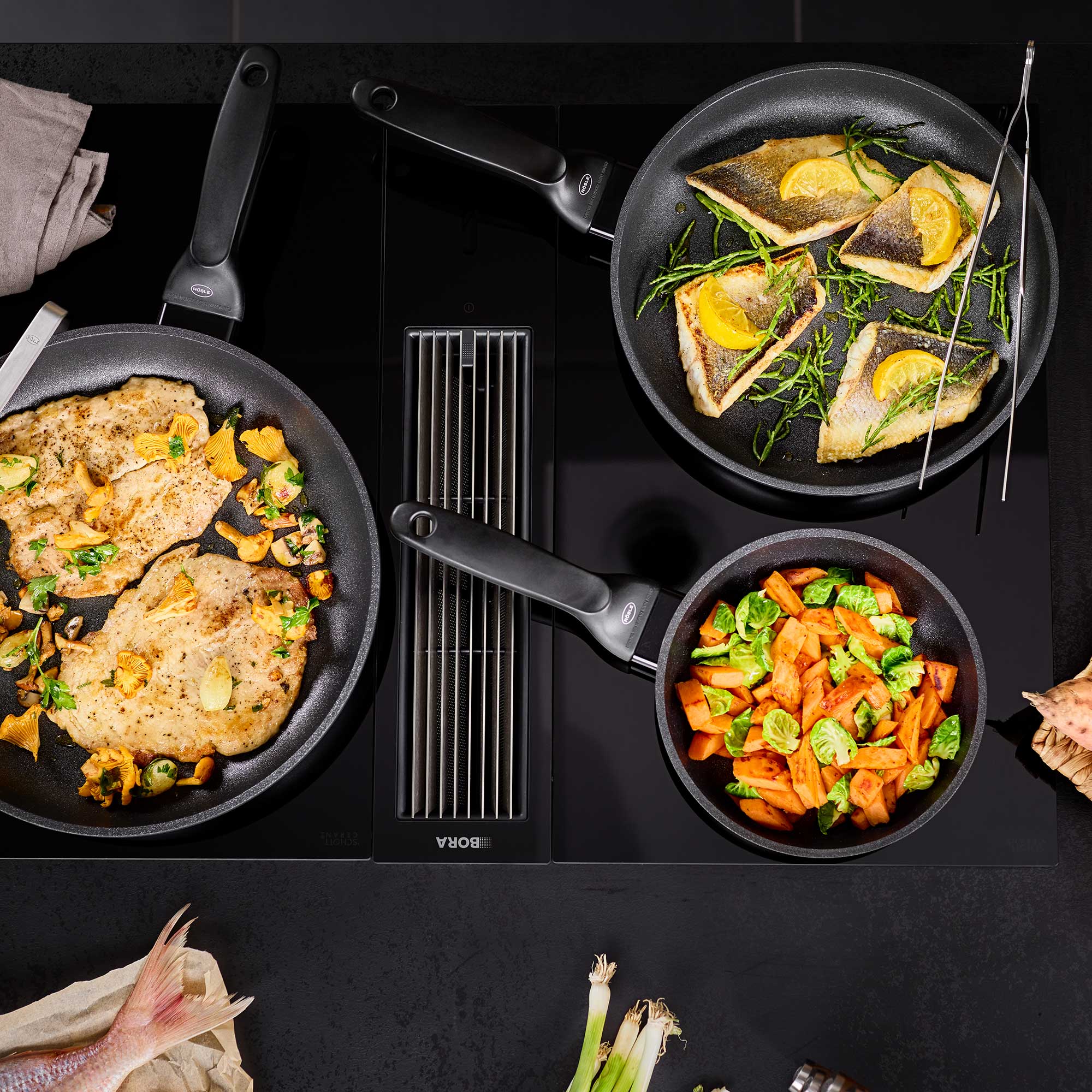 RÖSLE Bratpfanne Cadini mit gebratenem Fisch und Gemüse Bratpfanne Cadini, 20 cm, mit gebratenem Fisch und Gemüse auf einem Kochfeld.