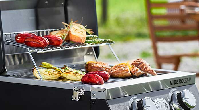 Various grilled food on the warming rack and grill surface of the Videro G2-P