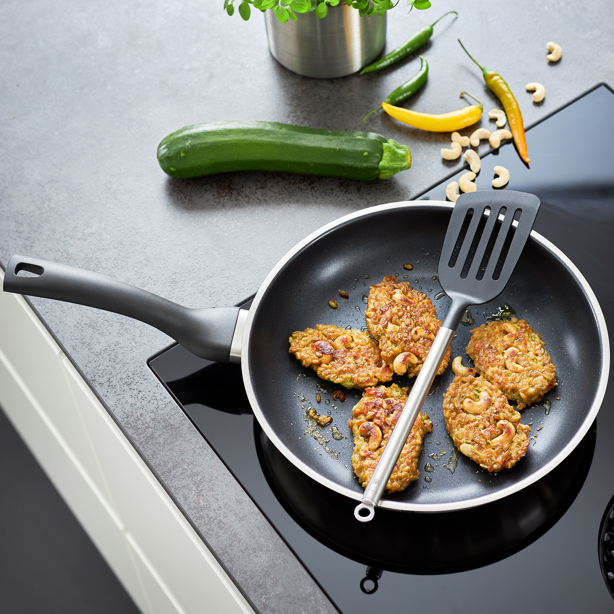 RÖSLE Pfannenwender 34 cm Pfannenwender aus Kunststoff, 34 cm, mit flacher Kelle, neben einer Pfanne mit Gemüse und...