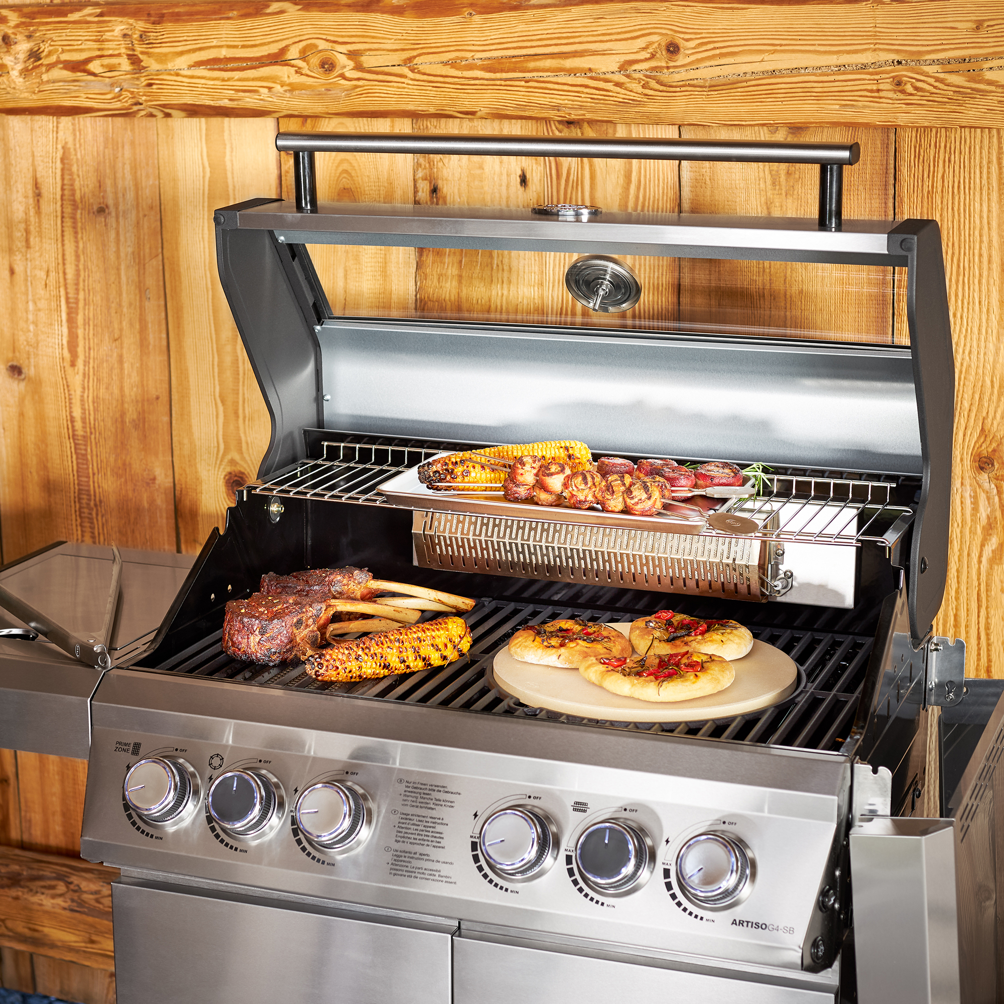 RÖSLE Gasgrill Artiso G4-SB Gasgrill Artiso G4-SB aus Edelstahl mit Grillgut wie Steak, Gemüse und Pizza auf dem Rost.
