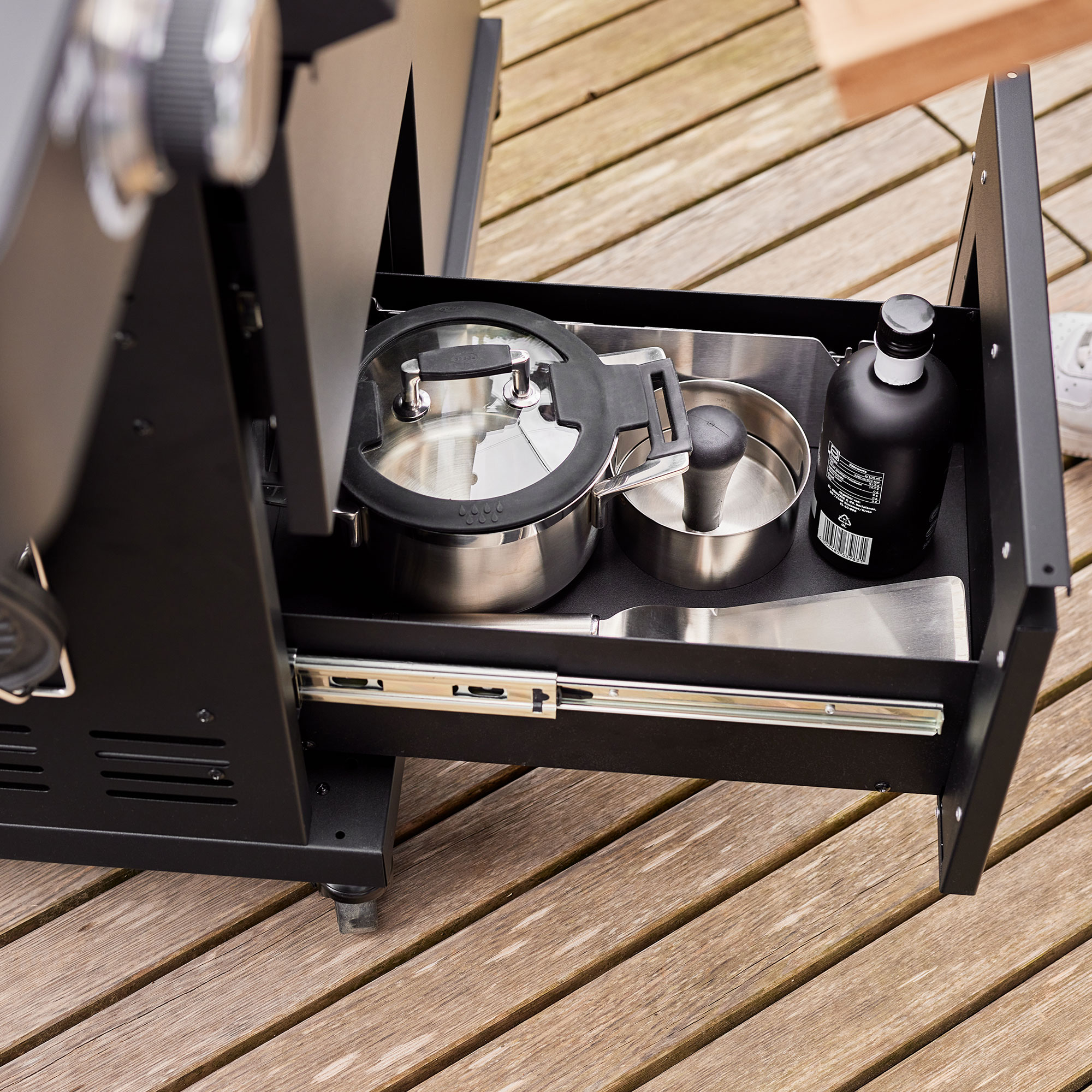 RÖSLE Gasgrill Videro G4-S PRO mit Zubehör Gasgrill Videro G4-S PRO mit offenen Schubladen, die Kochgeschirr und eine Flasche zeigen.