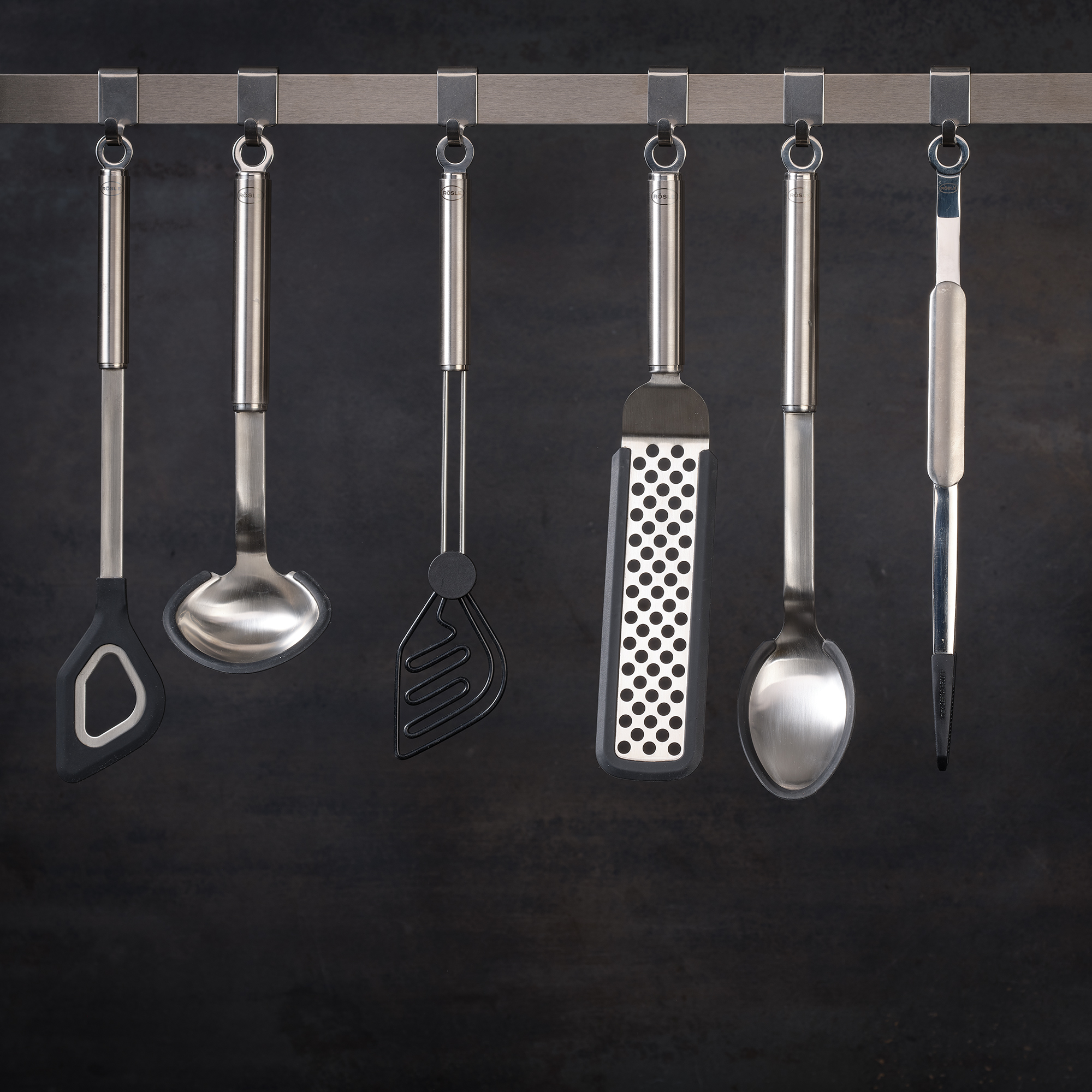 RÖSLE round handle silicone sauce spoon Round-handled silicone sauce spoon, hanging together with other stainless steel kitchen utensils.