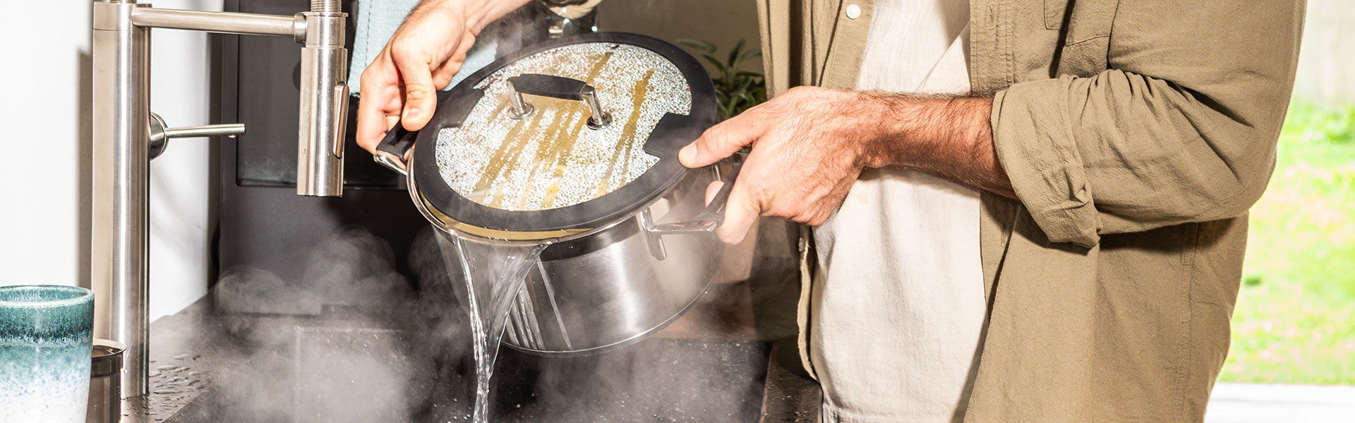RÖSLE Kochtopf mit Glasdeckel Kochtopf mit Glasdeckel, dampfend, wird über Spüle entleert.