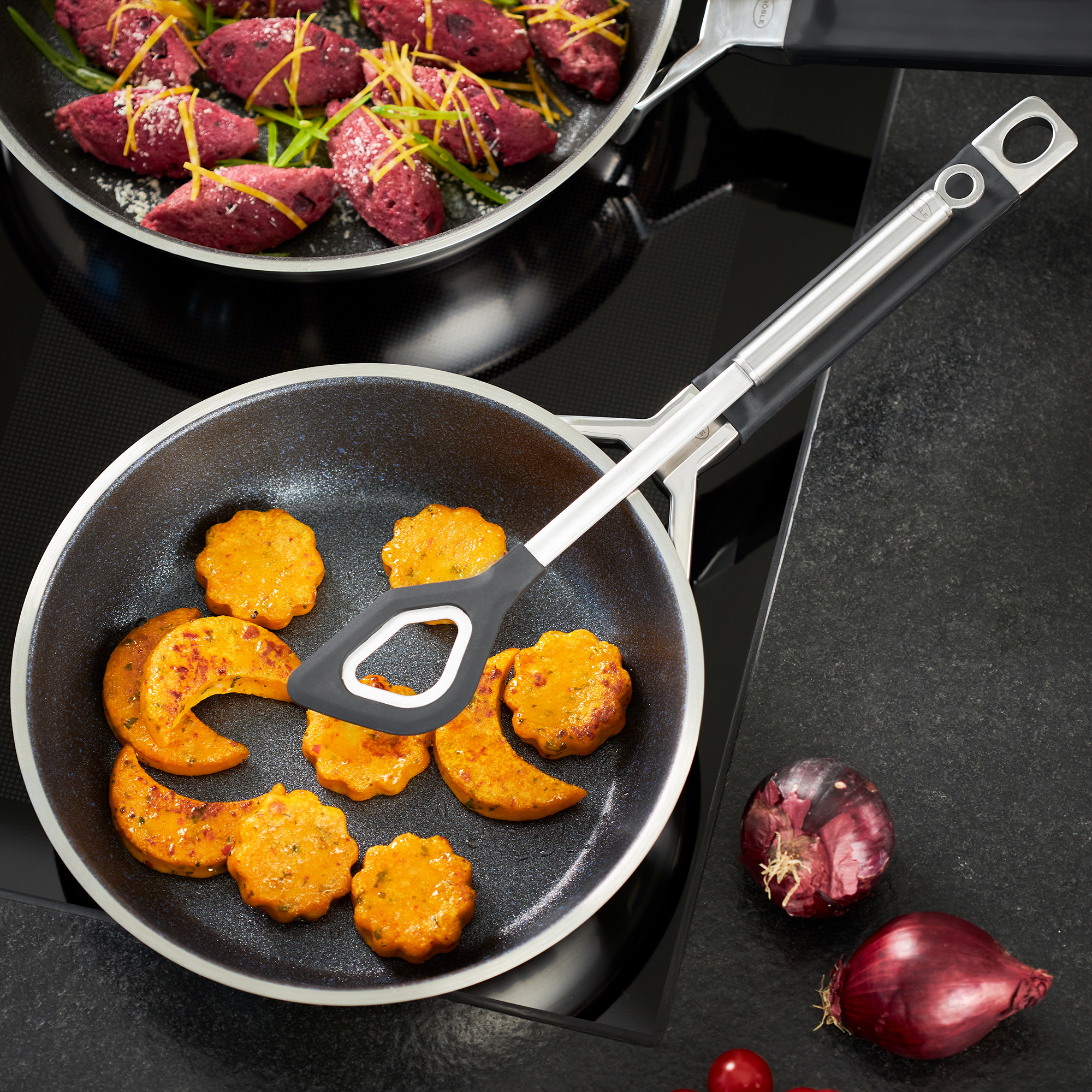 RÖSLE frying pan 24 cm Silence Pro Frying pan 24 cm from the Silence Pro series with orange-coloured vegetable patties and onions...