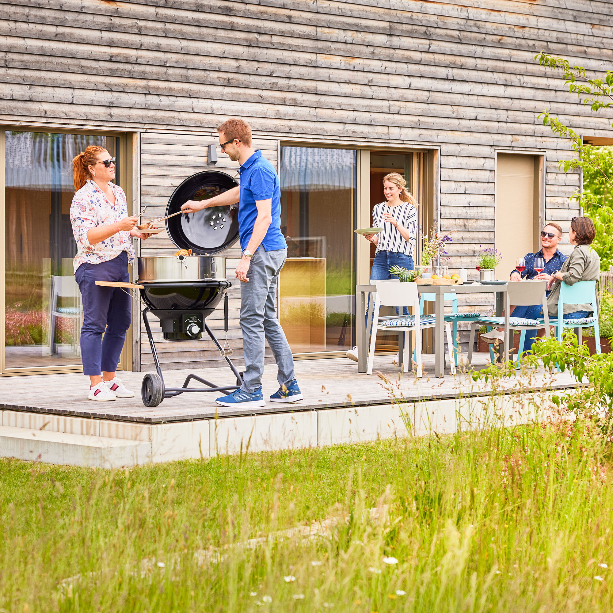 RÖSLE Holzkohle Kugelgrill No1 AIR F60 PRO auf Terrasse Holzkohle Kugelgrill No1 AIR F60 PRO im Einsatz auf einer Terrasse, mit Personen, die grillen...