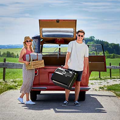 Couple having picnic. Woman with basket and man with Videro G2-P in hand.