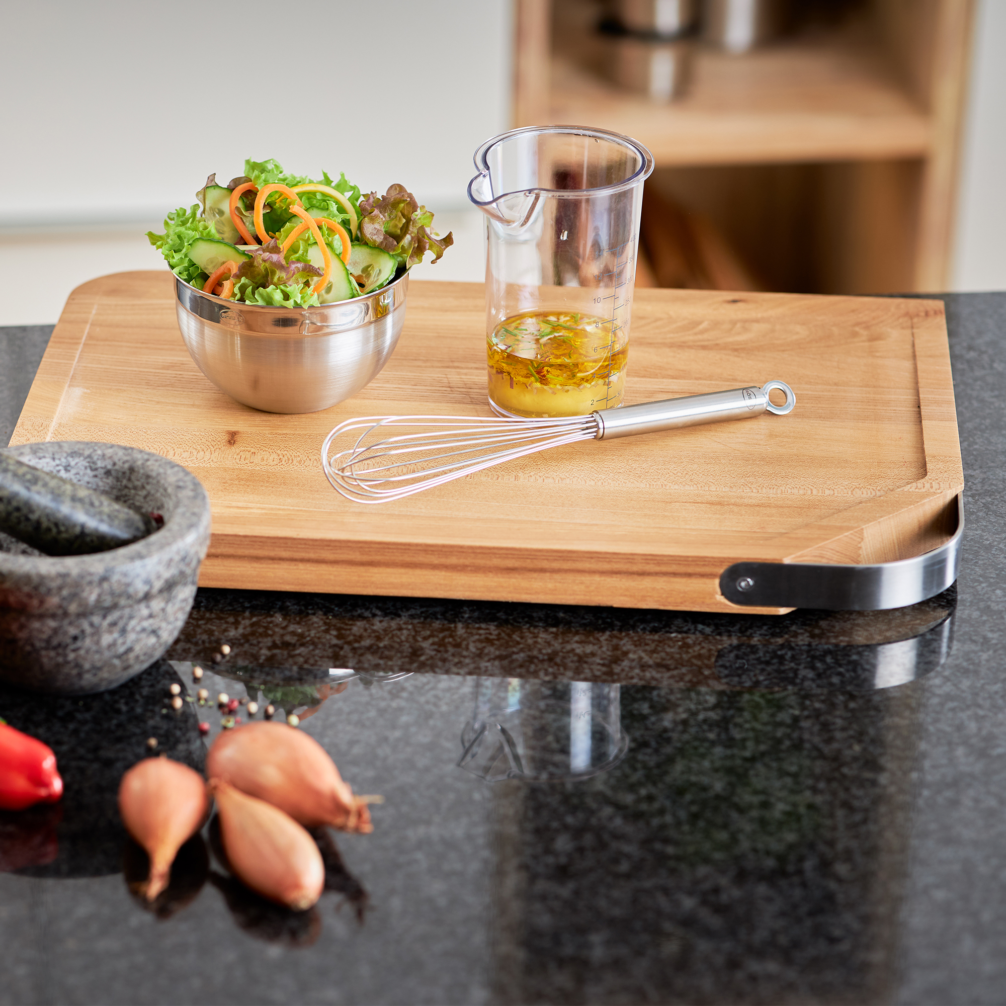 RÖSLE Holzschneidbrett mit Salat und Küchenutensilien Schneidbrett aus Holz mit einer Schüssel Salat, einem Messbecher mit Dressing und einem Schneebesen.