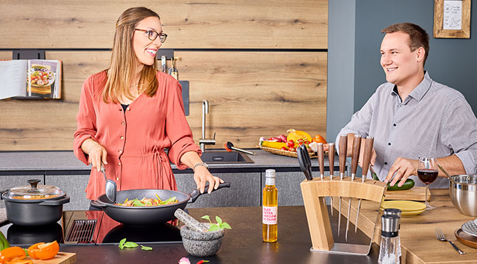 Couple cooks together in the wok pan and saucepan of cookware series Cadini