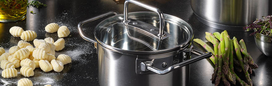 RÖSLE roestvrijstalen steelpan met glazen deksel Roestvrijstalen kookpot met glazen deksel, omringd door gnocchi en asperges.
