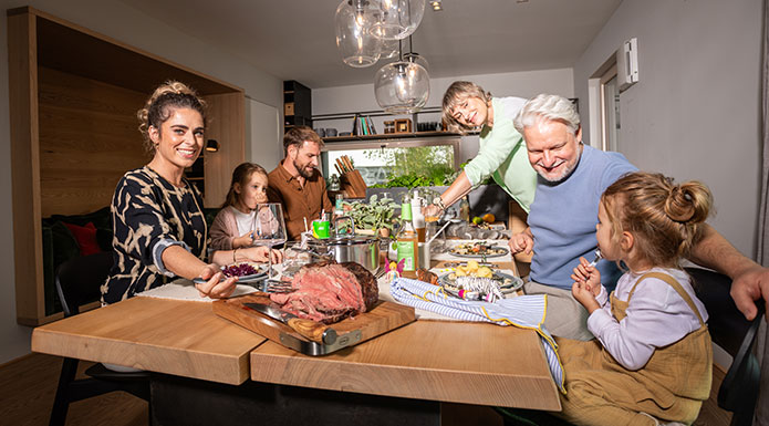 Family business Six family members sit together at the table and distribute the food