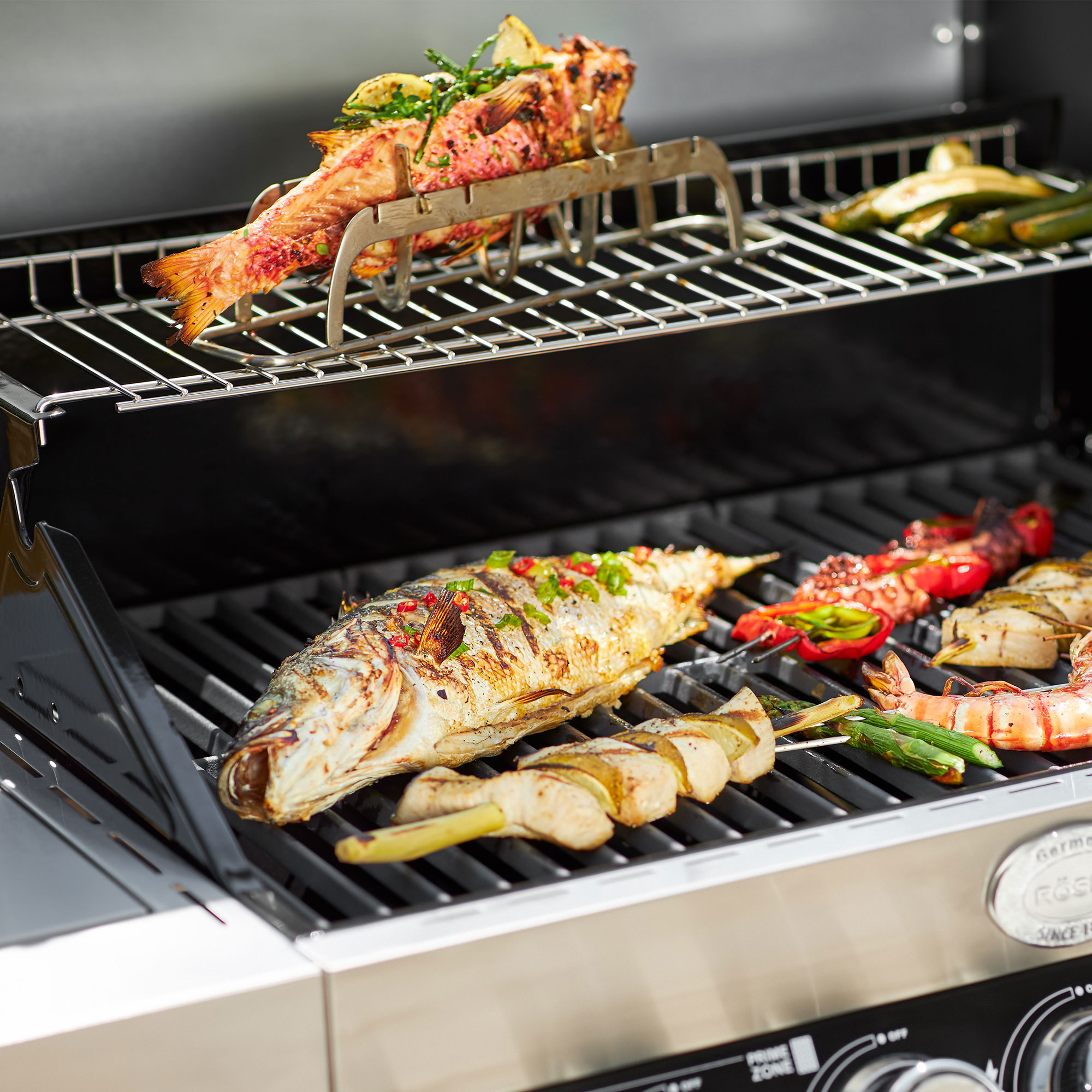 RÖSLE Fischhalter auf dem Grill Fischhalter mit gegrilltem Fisch und Gemüse auf einem Grillrost.