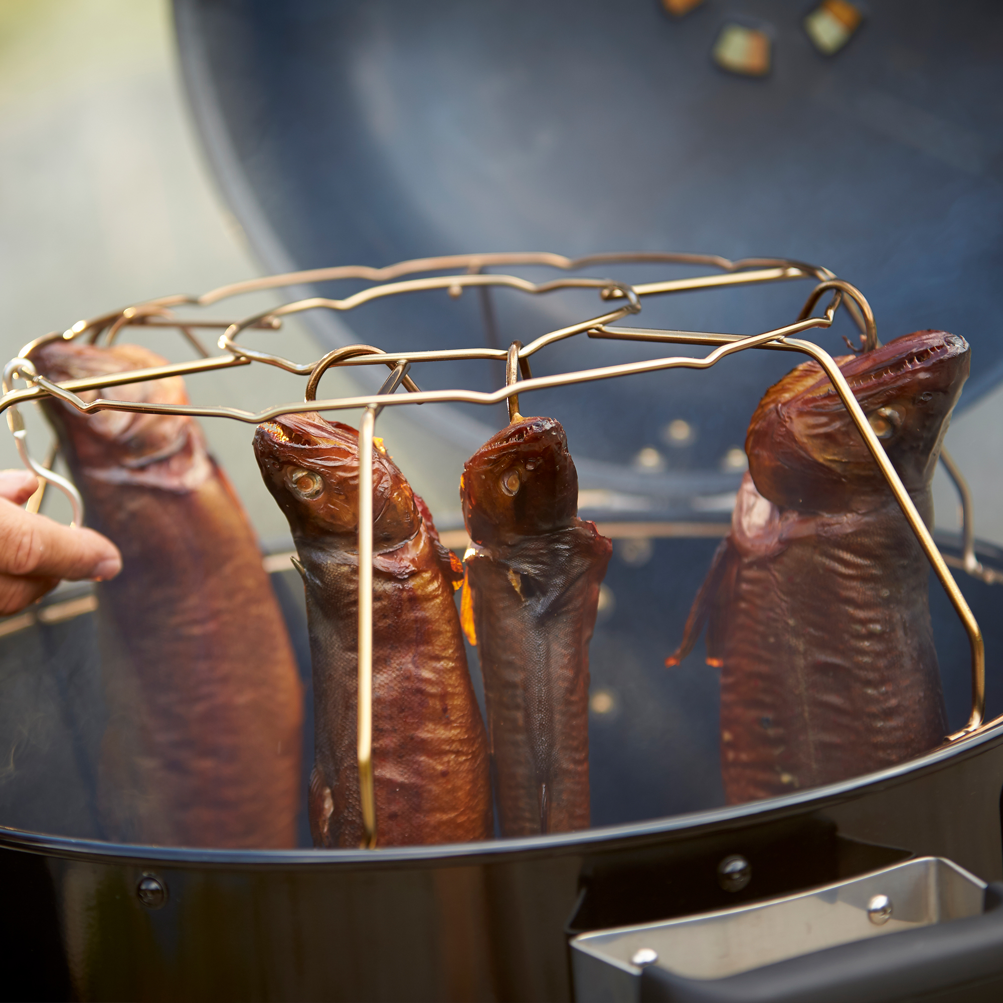RÖSLE Holzkohle Wasser Smoker mit Fisch Holzkohle Wasser Smoker mit geräuchertem Fisch im Gitter.