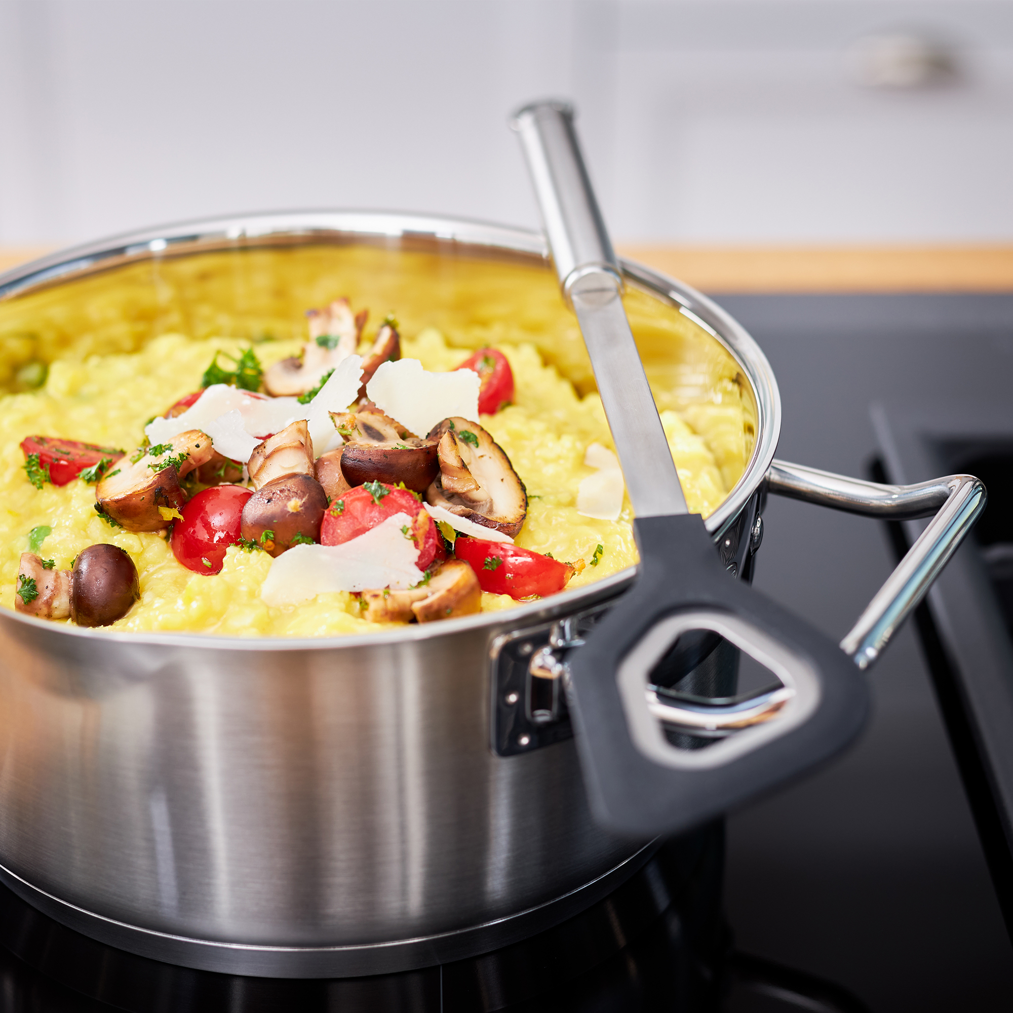 RÖSLE silicone cooking spoon in use Cooking spoon with silicone round handle, used in a pot with risotto and vegetables.