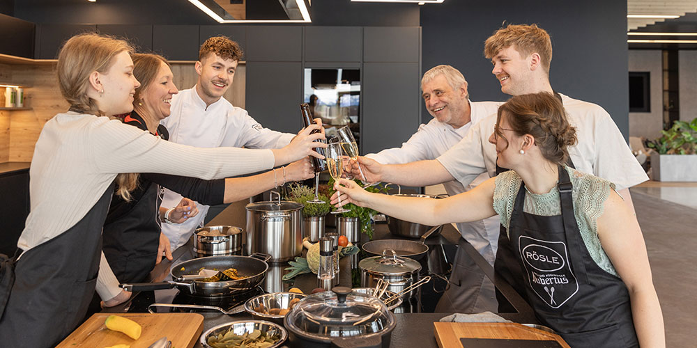 Grill-und Kochschule Teilnehmer des Kochkurses stoßen zusammen an