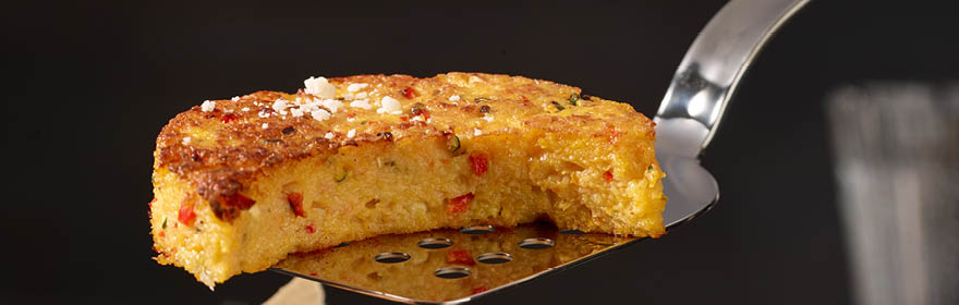 RÖSLE spatel met geroosterde groenten Roestvrijstalen spatel tilt een stuk gebakken groenteschotel met een goudbruin korstje op.