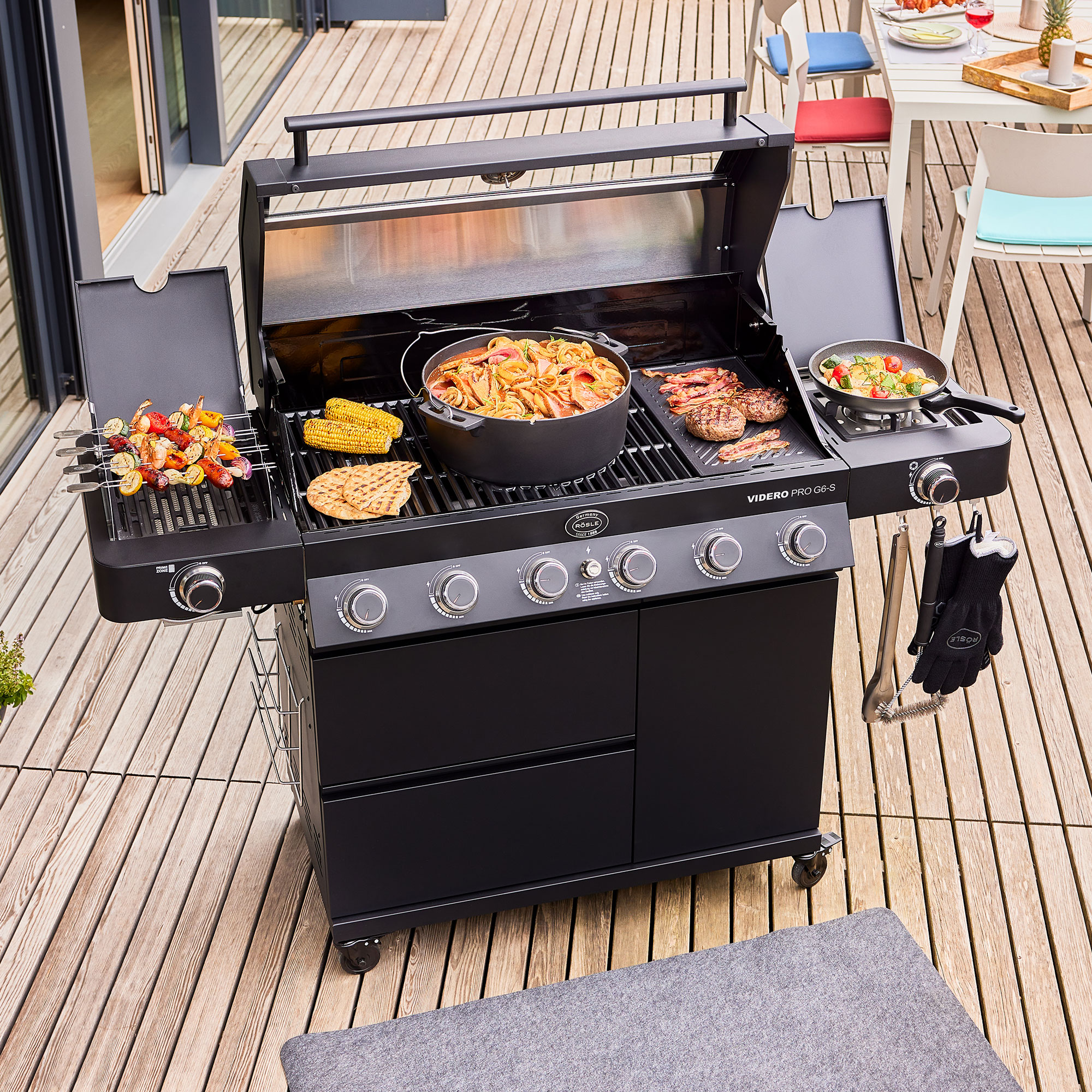 RÖSLE Gasgrill Videro G6-S PRO Gasgrill Videro G6-S PRO mit geöffnetem Deckel, Grillgut und Pfannen auf dem Grillrost.