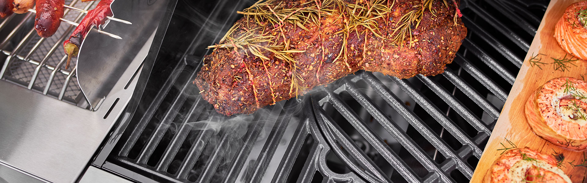 Grillrost mit Fleisch und Rosmarin Grillrost mit mariniertem Fleisch und Rosmarin, Rauchentwicklung sichtbar.