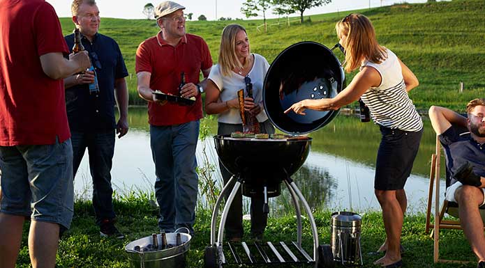 Friends barbecue with the charcoal kettle grill No.1 Sport F50 at the lake
